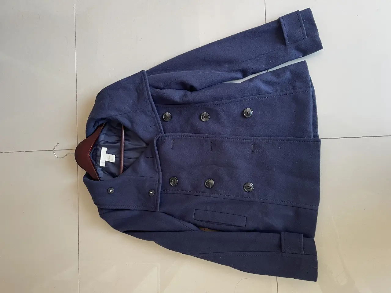 Tapado de paño azul marino, con botones y solapas. Sin uso.