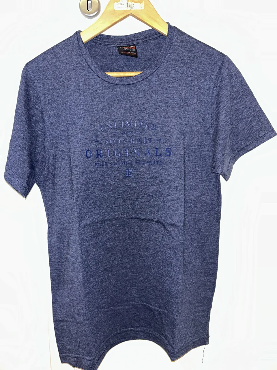 Remera azul marino de manga corta con estampa "UNLIMITED ORIGINALS" en el frente. Ideal para un look casual y moderno.