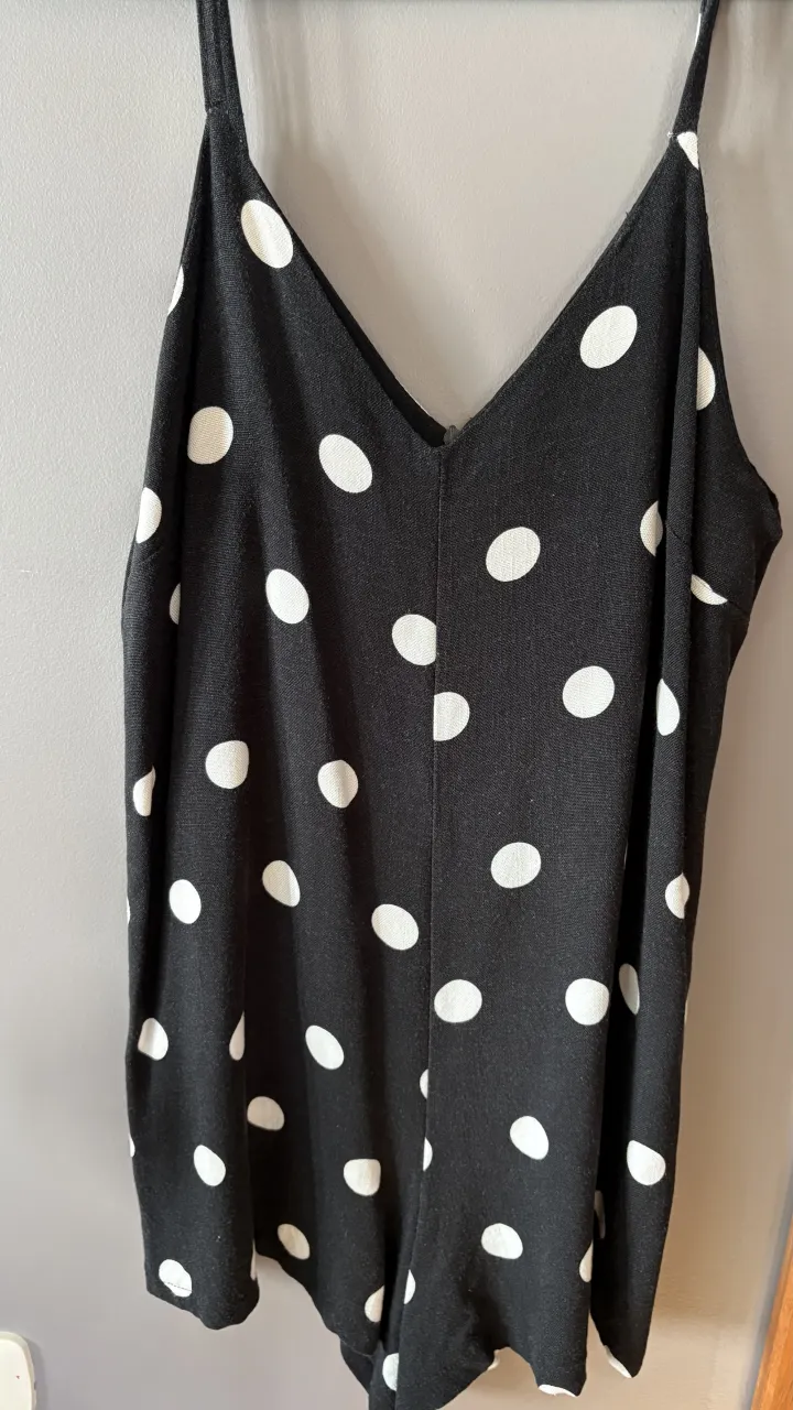 Mono corto negro con lunares blancos. Breteles finos y escote en V.