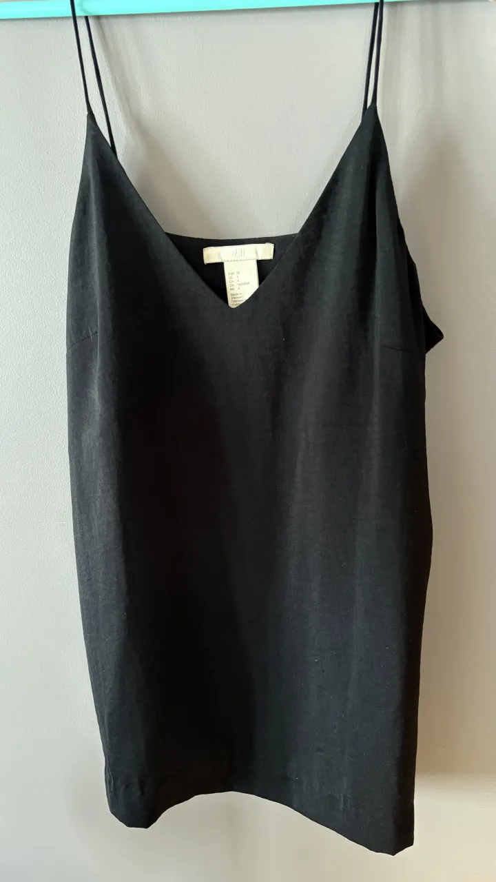 Musculosa negra con breteles finos y escote en V.
