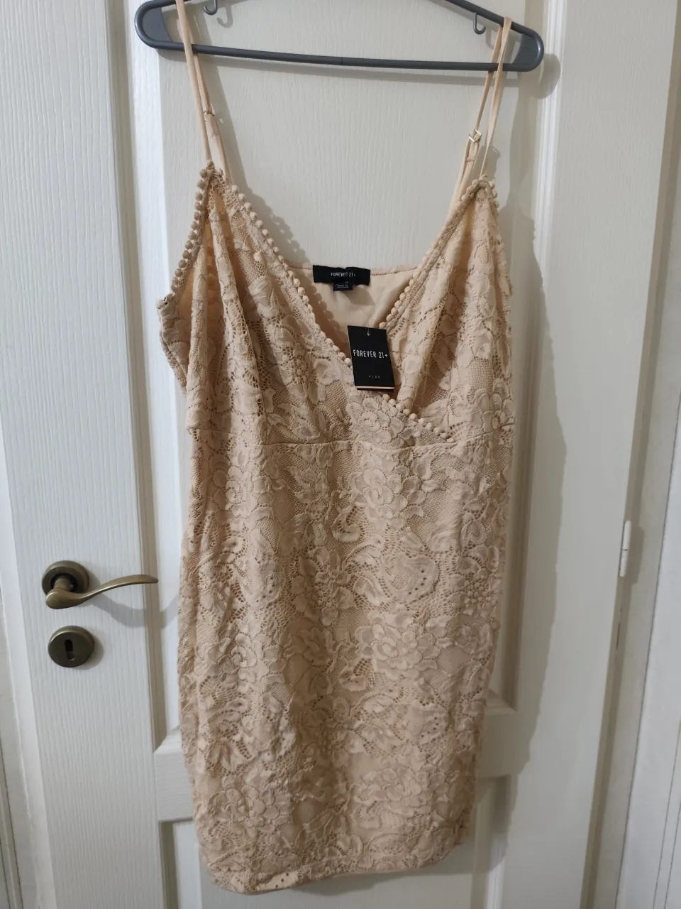 Vestido de encaje color beige con tirantes finos y detalle de pompones en el escote y breteles regulables. Largo hasta la rodilla. Con forro interior. Talle 3X. se pasan medidas