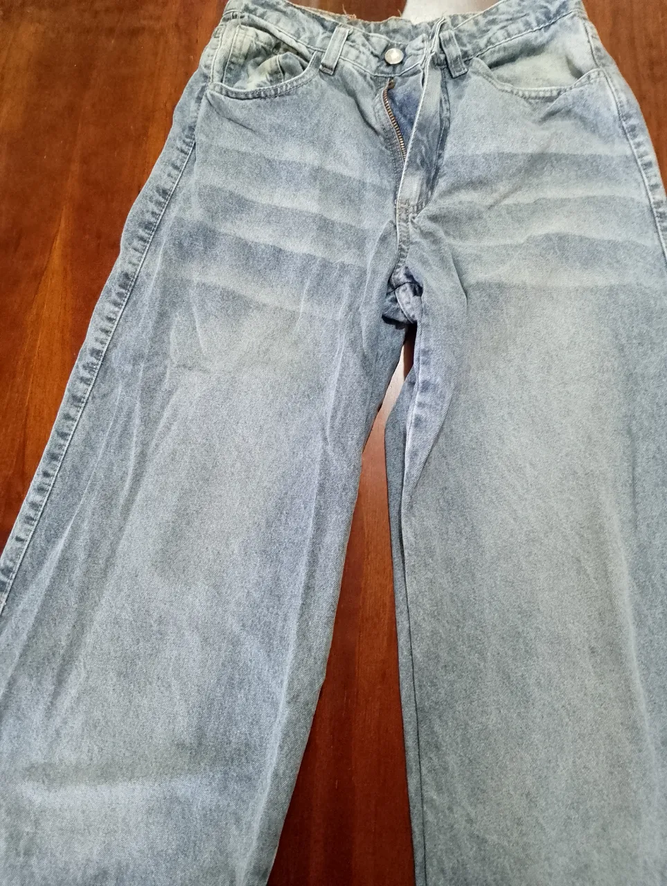 Jean de tiro alto con cierre y botón. Posee bolsillos delanteros y traseros.