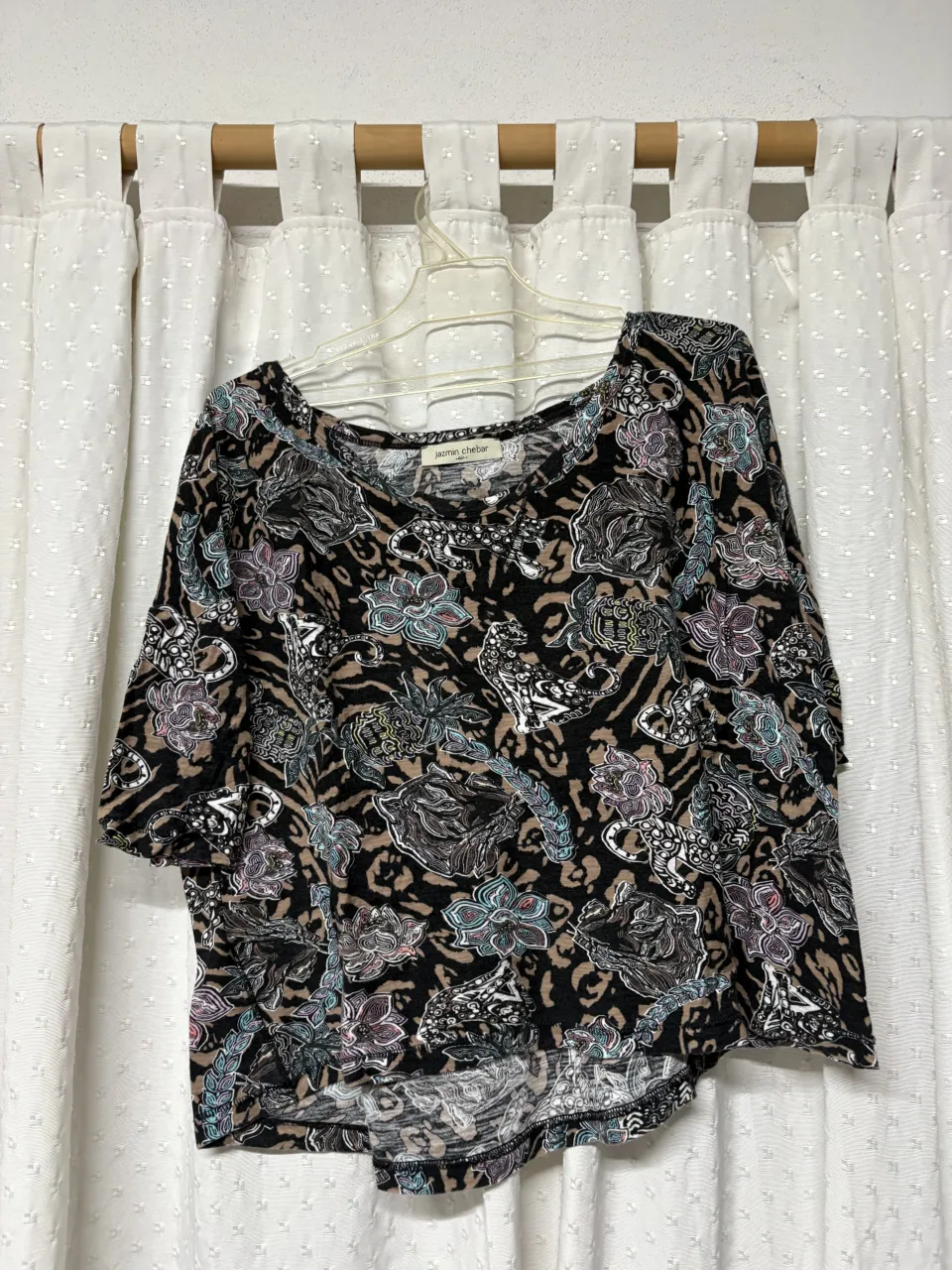 Remera estampada con motivos florales y de animales, con mangas cortas y cuello redondo.