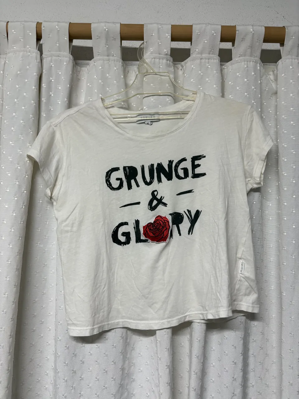 Remera blanca de manga corta con estampa "GRUNGE & GLORY" en negro y una rosa roja en el centro.