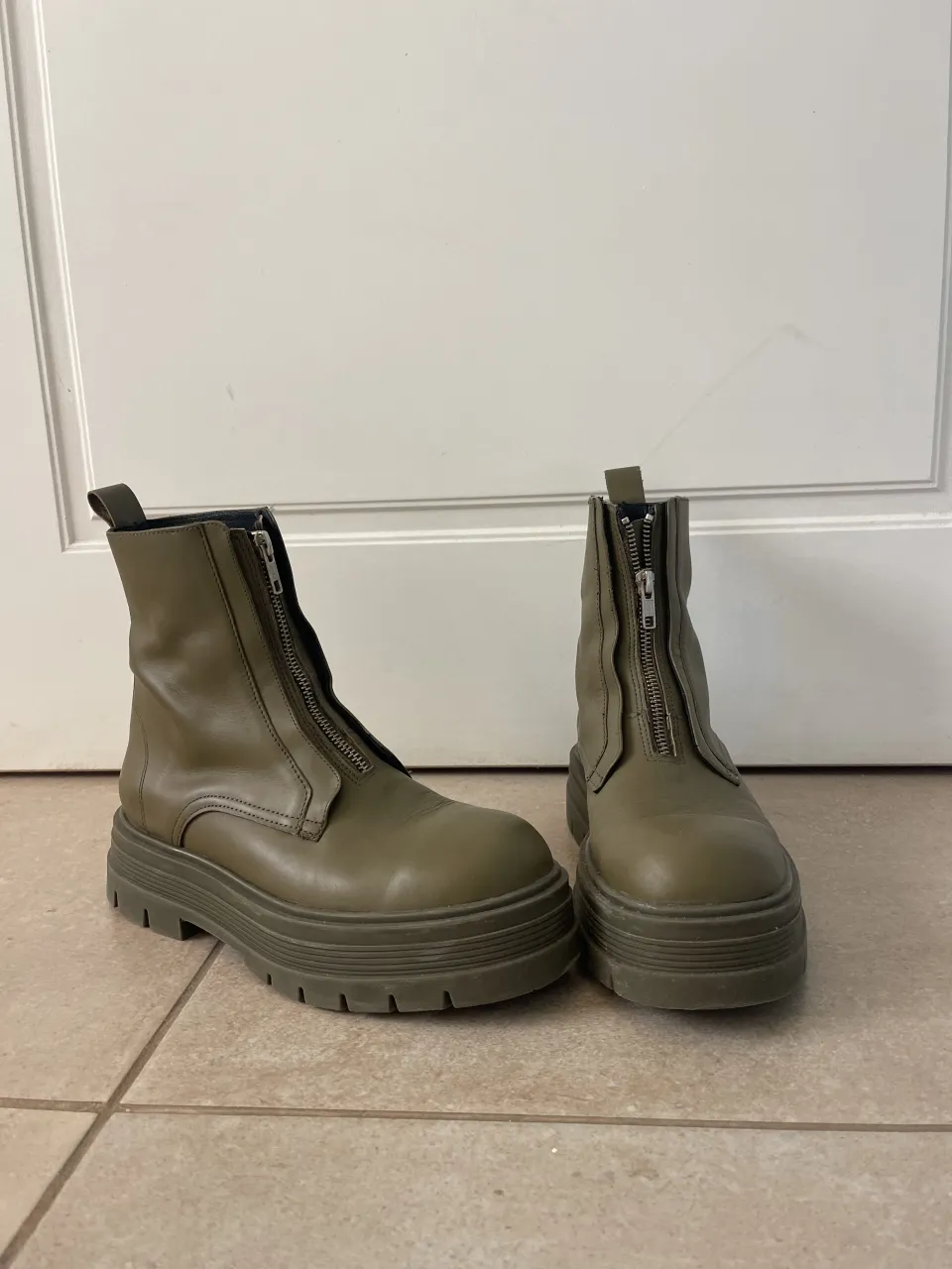 Botas de caña baja color verde militar con cierre delantero y suela track.