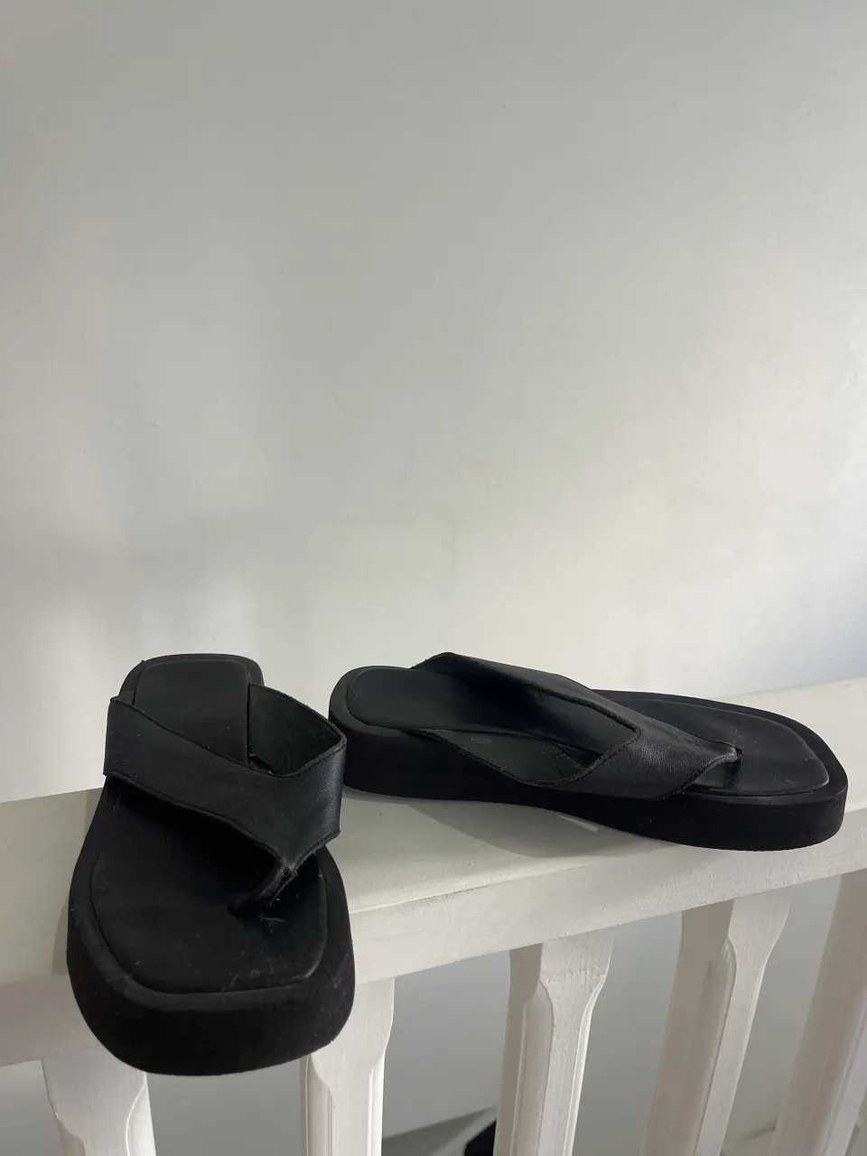 Ojotas negras de cuero con plataforma.