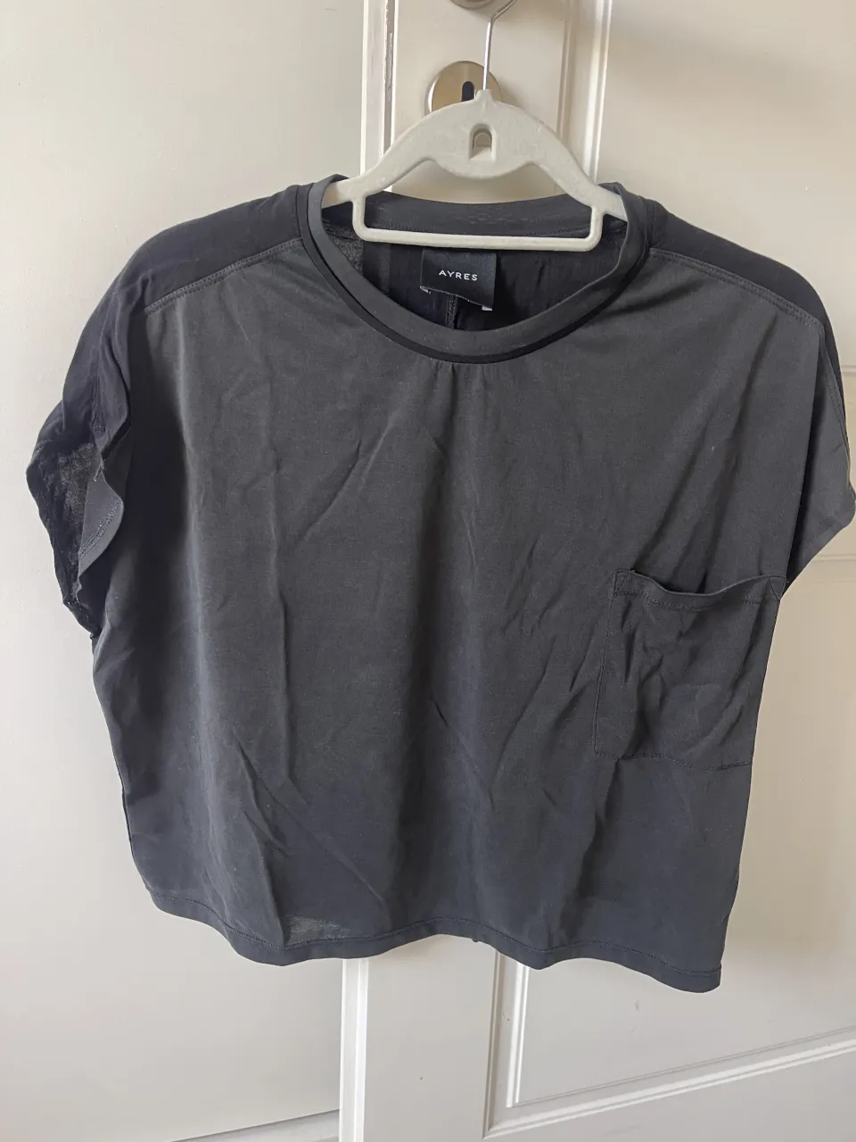 Remera negra de manga corta con un bolsillo en el frente.