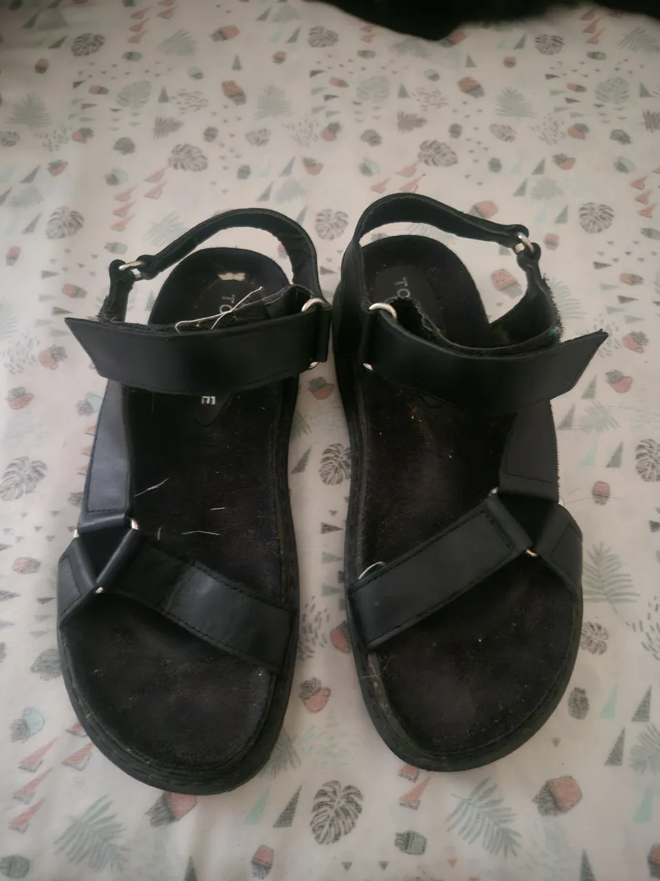 Sandalias negras de tiras, ideales para el verano. Cuentan con ajuste de velcro para mayor comodidad.