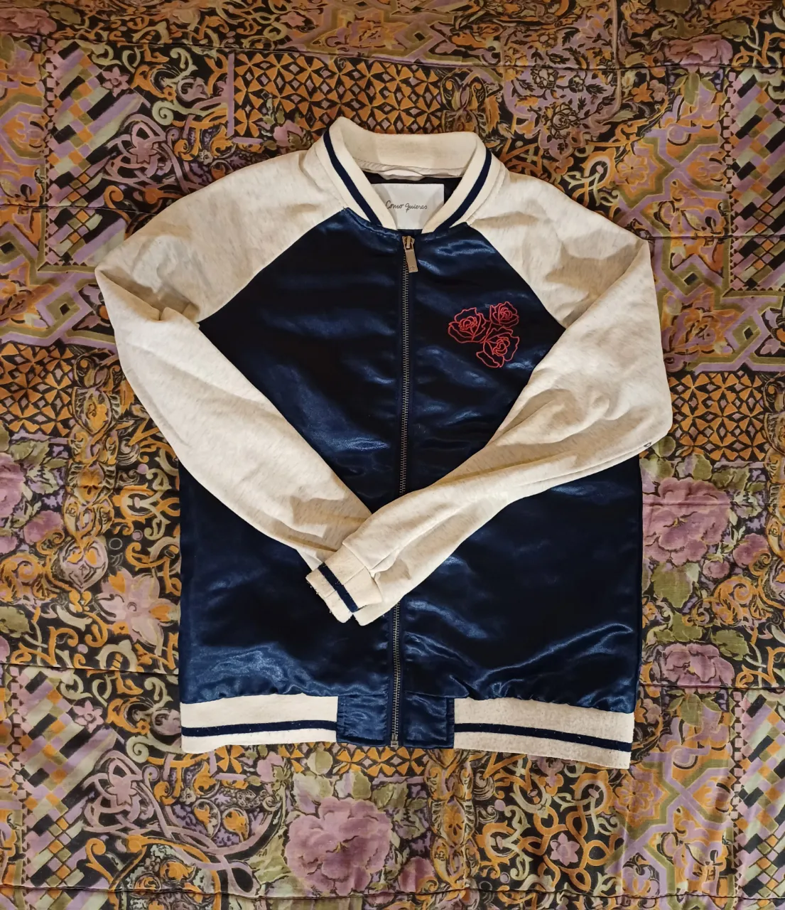 Campera estilo bomber con mangas color gris claro y cuerpo azul marino. Posee bordado de tres rosas rojas en el frente y un estampado grande en la espalda con un tigre, rosas y la inscripción "WILD ROSES TIGER LADIES". Puños y cuello con detalles de franjas azules.
sisa a sisa: 44 cm
largo de mangas: 62 cm
largo: 60 cm
Detalle de pelotitas en la última foto!