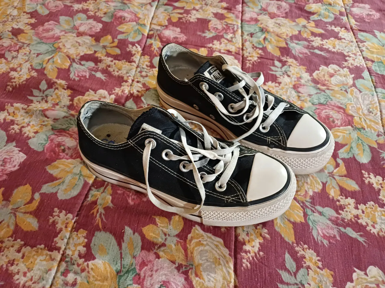 Zapatillas Converse All Star negras con cordones blancos y plataforma. Detalle de logo en la lengüeta y en la parte trasera.