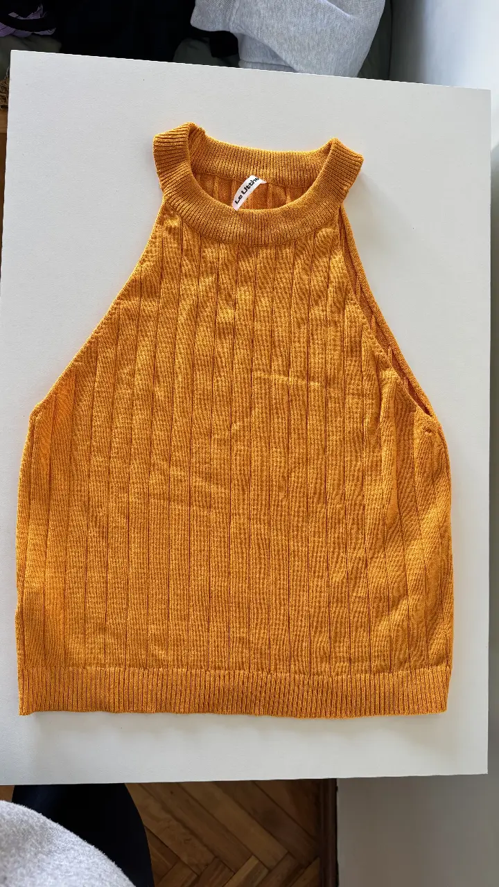 Top tejido de punto, de cuello alto y corte halter. Ideal para un look moderno y sofisticado.