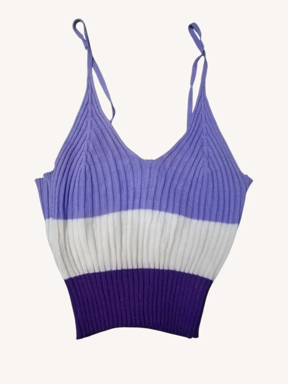 Top de tejido acanalado con tiras finas y escote en V. Diseño a rayas horizontales en tonos lila, blanco y violeta. Ideal para un look casual y fresco.