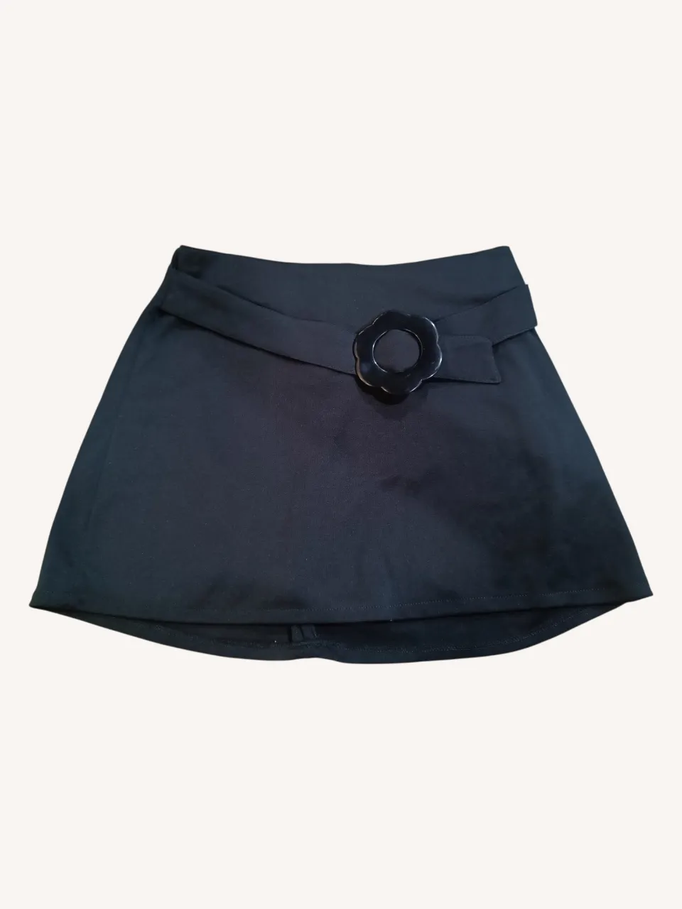 Minifalda negra corta con detalle de hebilla en forma de flor en la cintura.
📏 Medidas: cintura 32 cm.
‼️Tiene una de las pincitas descosida.