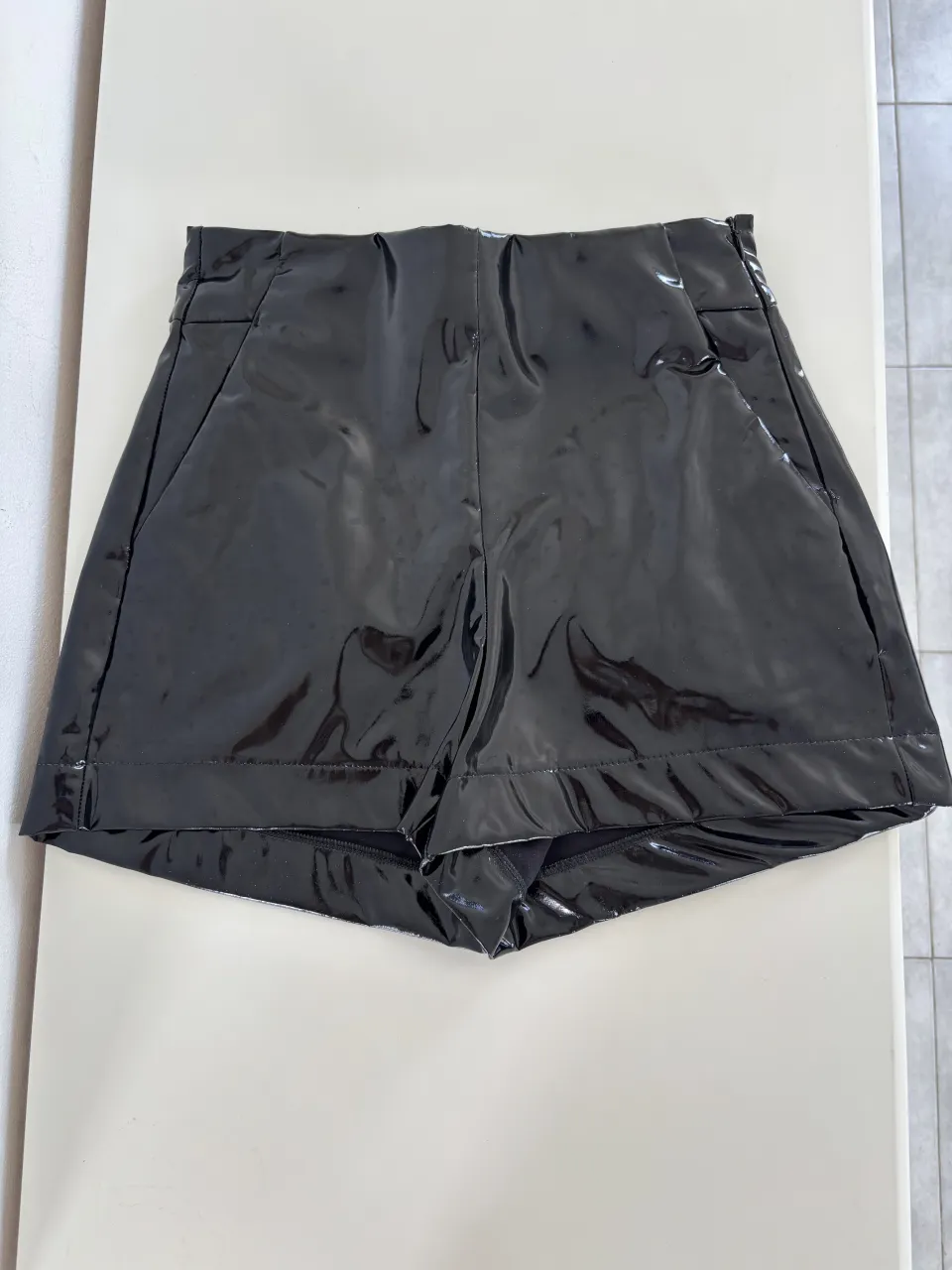 Shorts negros de vinilo con bolsillos delanteros.