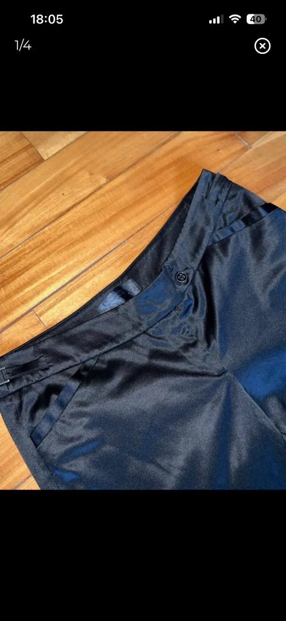 Pantalón negro de tela satinada con bolsillos delanteros y un botón en la cintura. Tiro Bajo marca Markova.
medidas:
cintura 46 cm
cadera 54 cm
largo 100 cm 