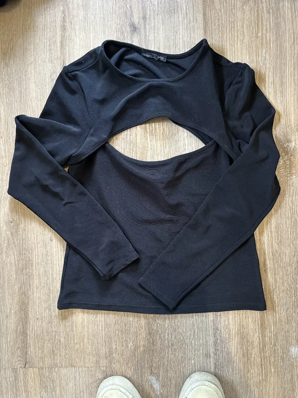 Remera negra de manga larga con abertura en el pecho. Ideal para un look moderno y audaz.