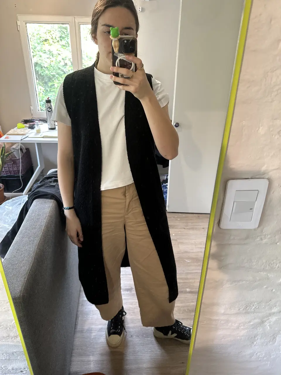 Chaleco largo de tejido de punto negro, con cinturón para ajustar en la cintura. Ideal para un look casual y moderno. 