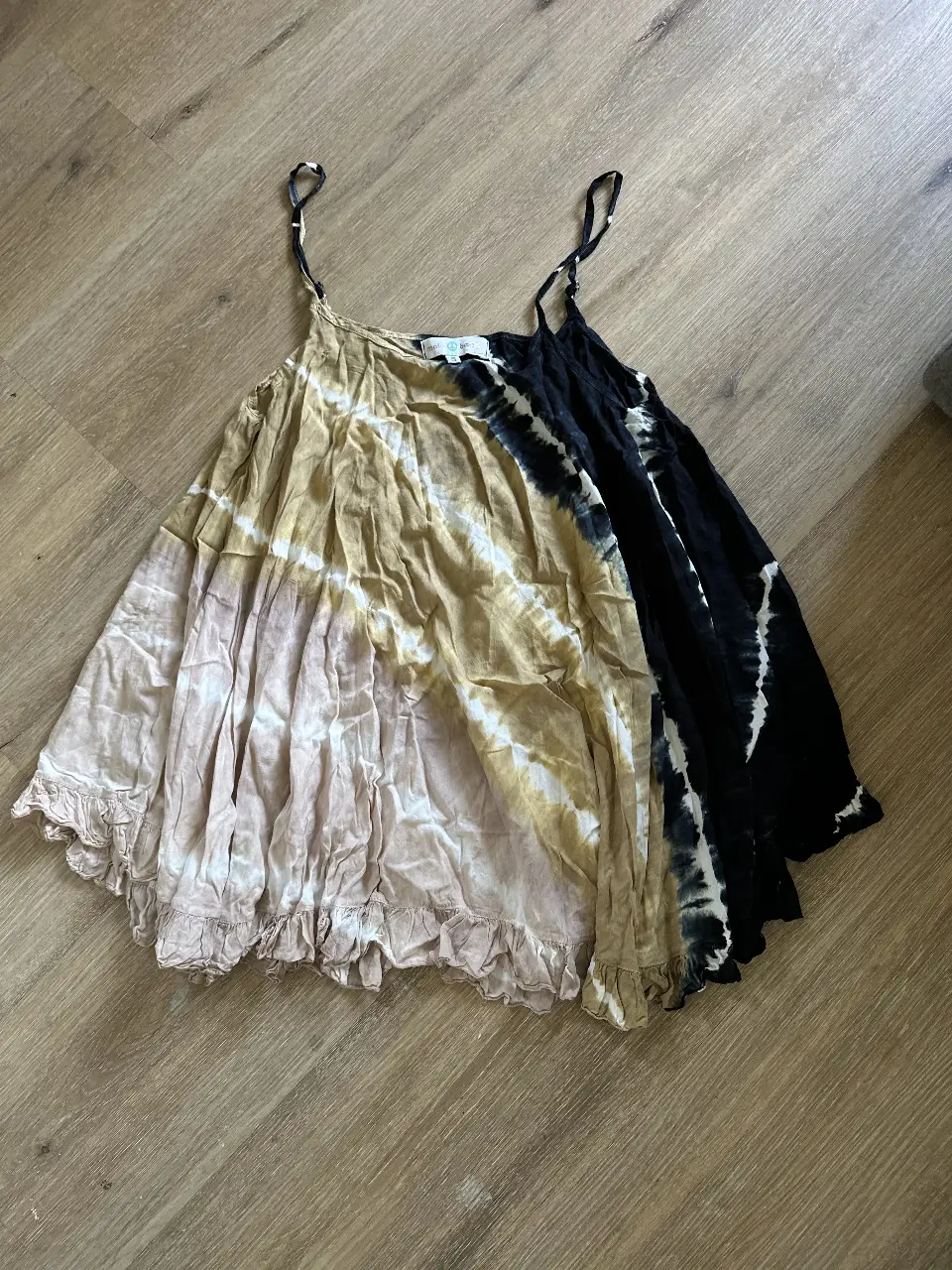 Top de mujer estilo boho con diseño tie dye en tonos amarillos y negros. Confeccionado en tela liviana y fresca, ideal para el verano. Detalles de volados en el borde inferior y tiras finas ajustables.