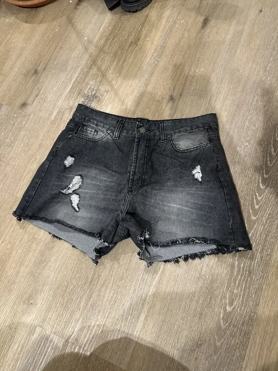 Short de jean negro con detalles rotos y desflecado. Talle 44. Ideal para un look casual y canchero.