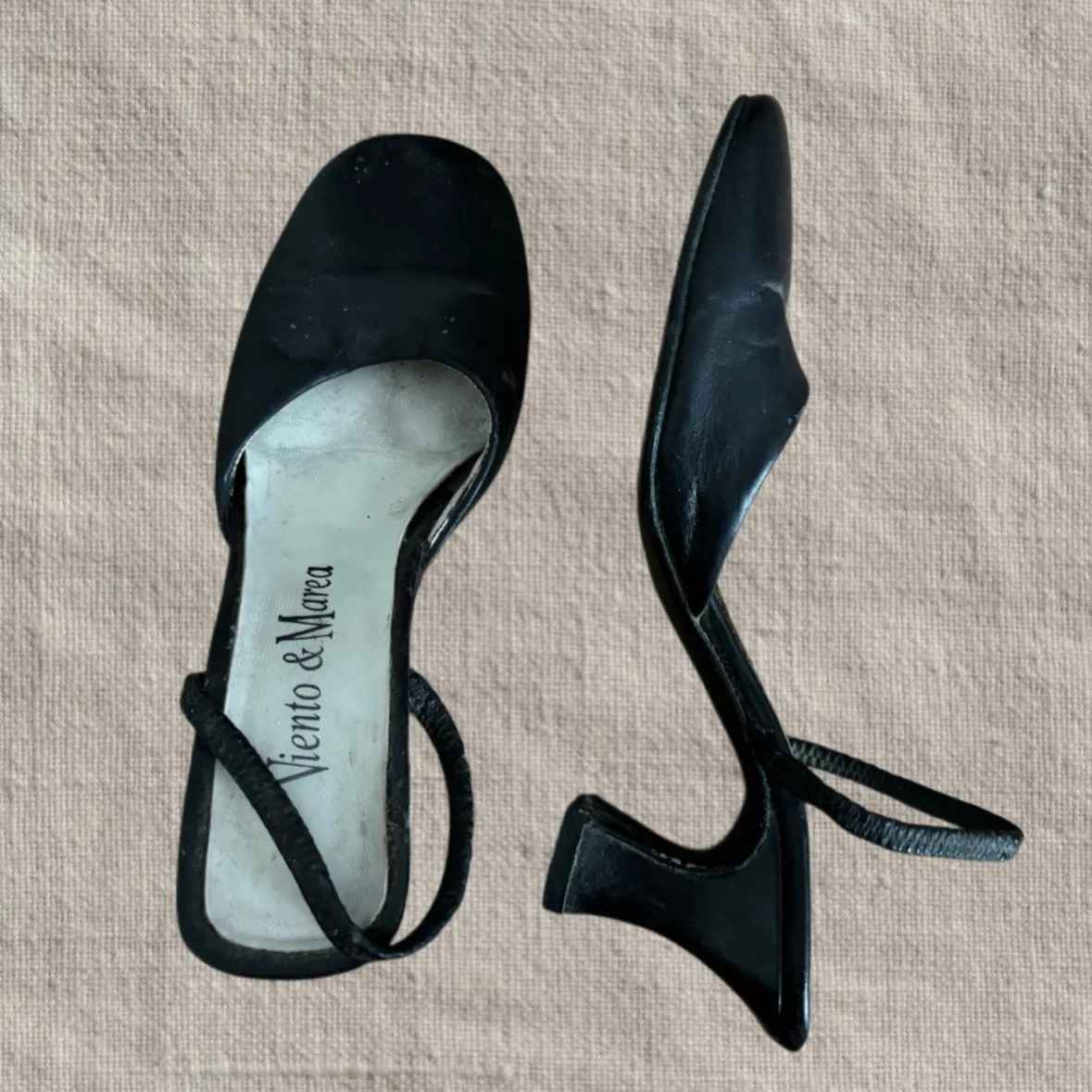 Zapatos negros de cuero con tiras finas y taco bajo.