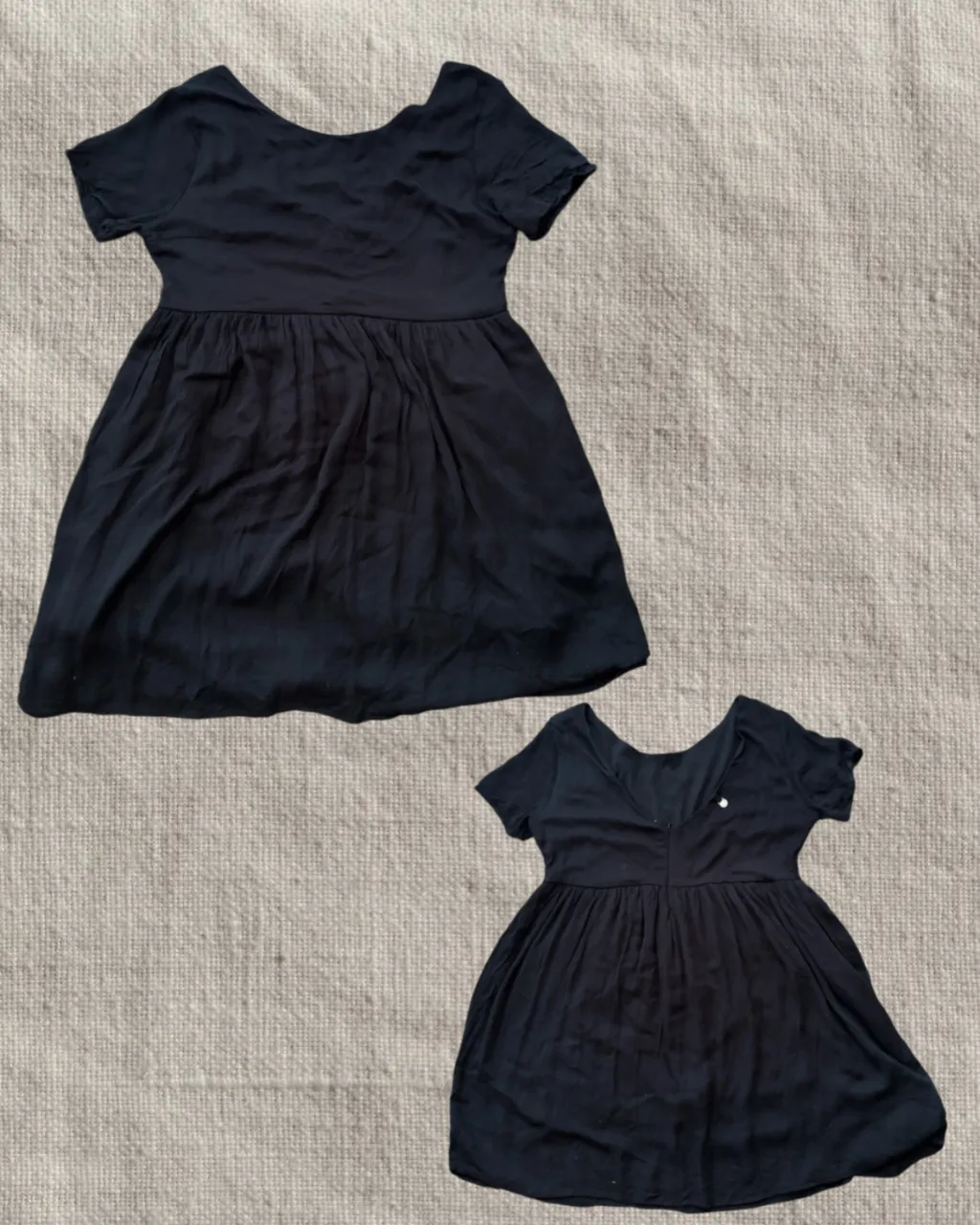 Vestido negro de manga corta con falda con vuelo, Con espalda en V y cierre.