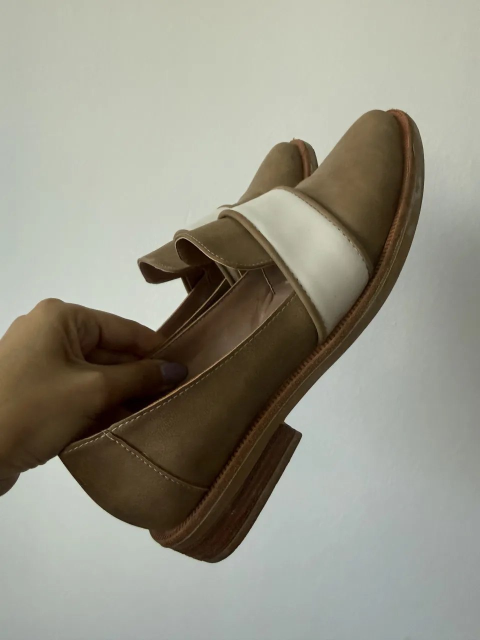 Zapatos estilo mocasín color suela con detalle de tira blanca en el empeine. Diseño abierto en los laterales.