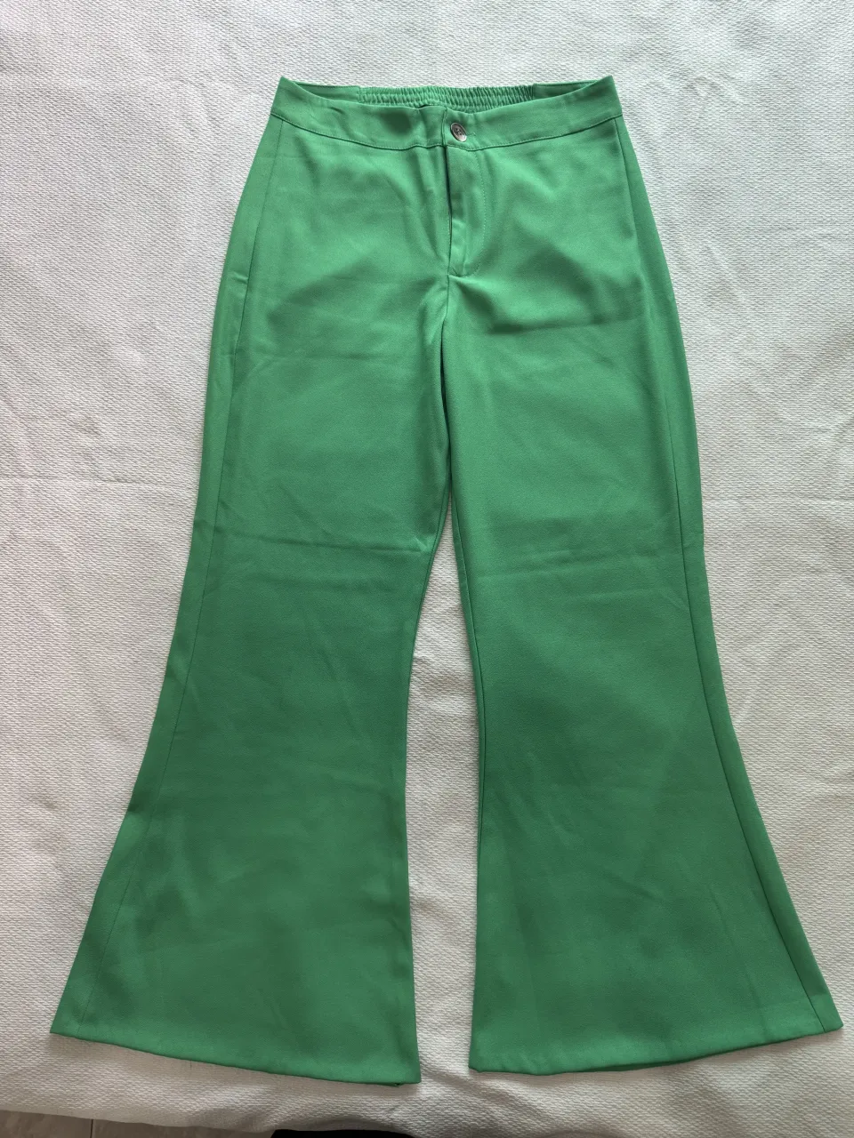 Pantalón verde con bolsillos traseros y cintura elastizada.