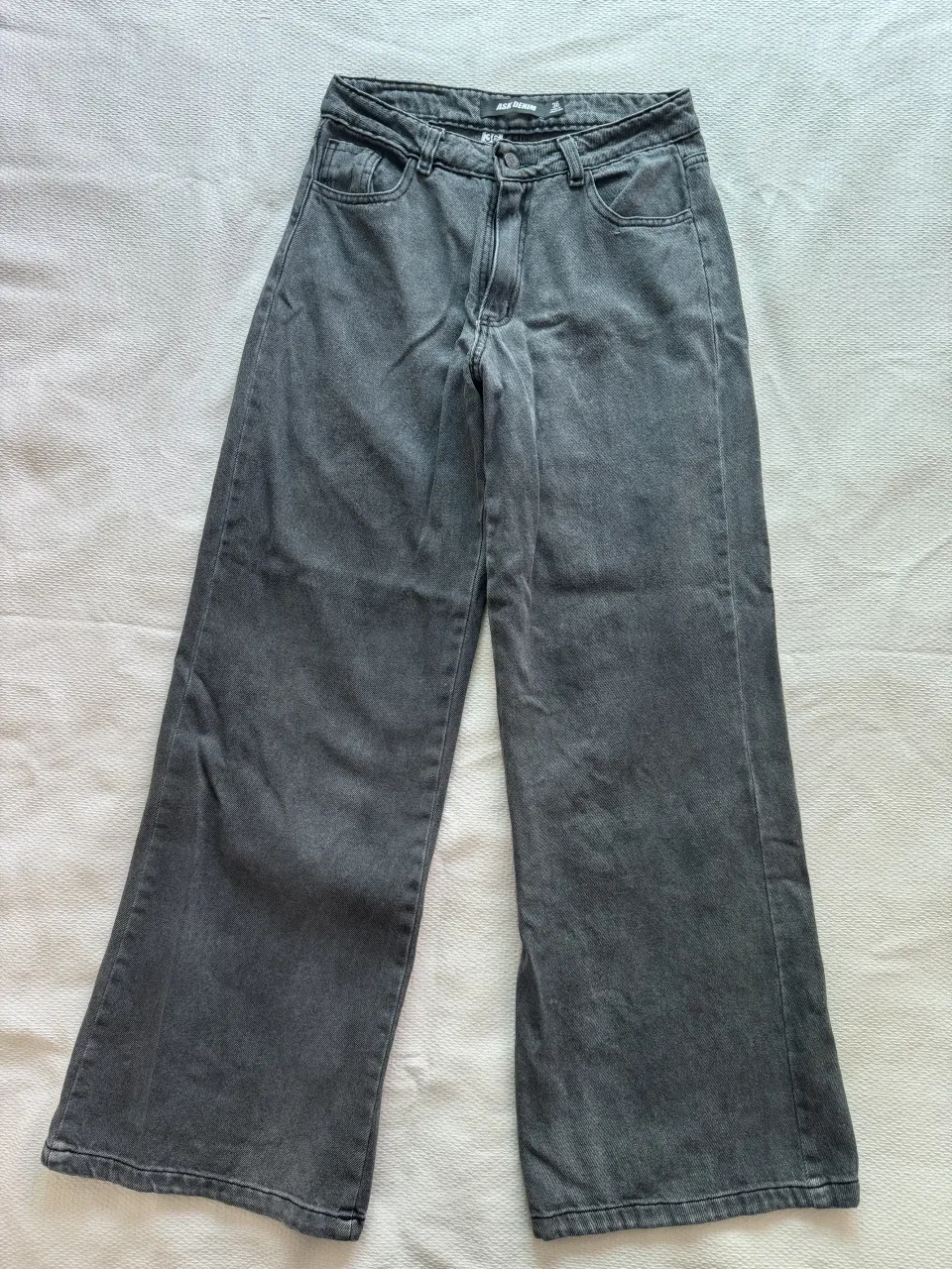 Jean de algodón color gris oscuro. Posee bolsillos delanteros y traseros.