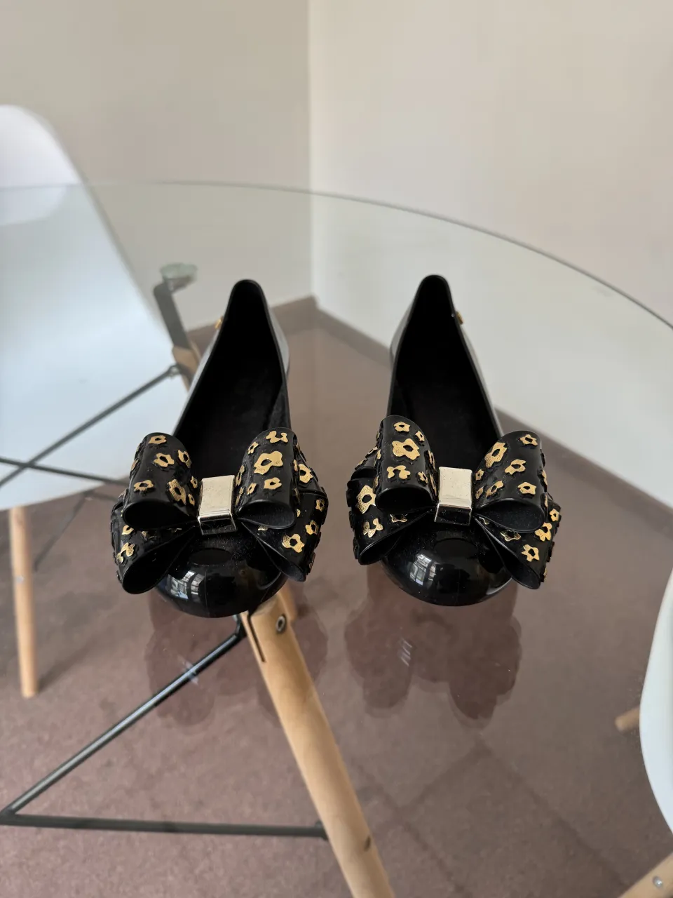 Zapatos negros con moño grande decorado con estampa animal print en dorado.