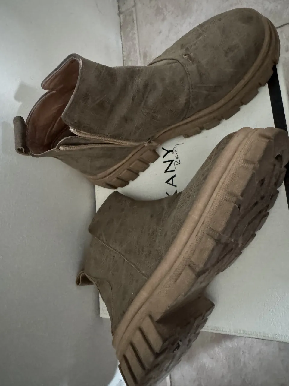 Botas de cuero color marrón con cierre lateral y suela gruesa.