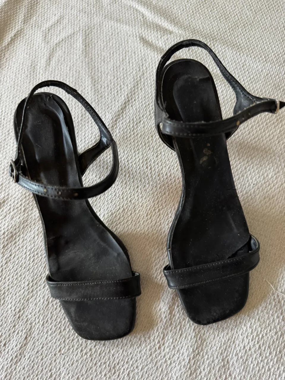 Sandalias negras con tiras finas y hebilla. Taco fino.