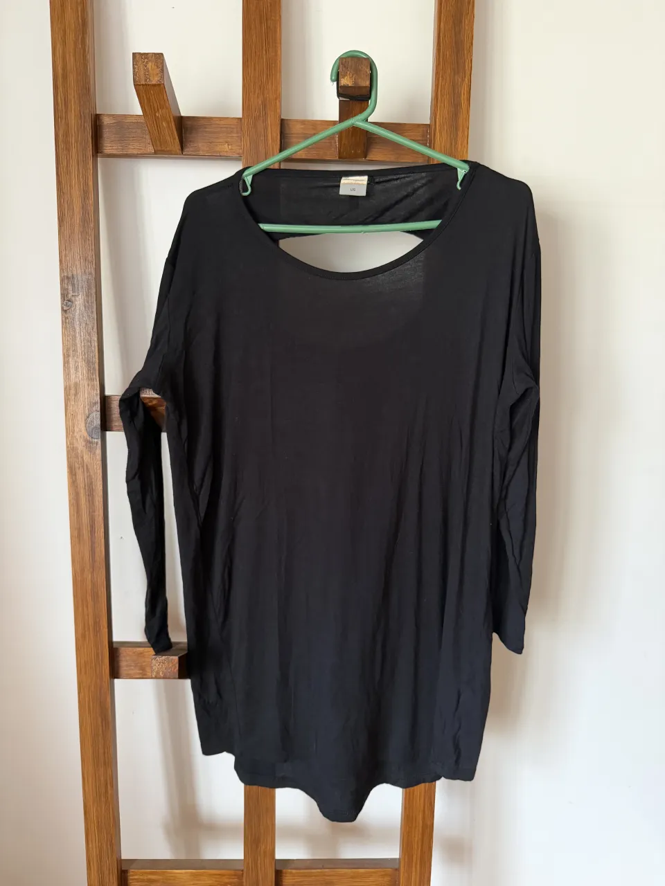 Remera negra de manga larga con un corte original en la espalda. Perfecta para un look casual y moderno.