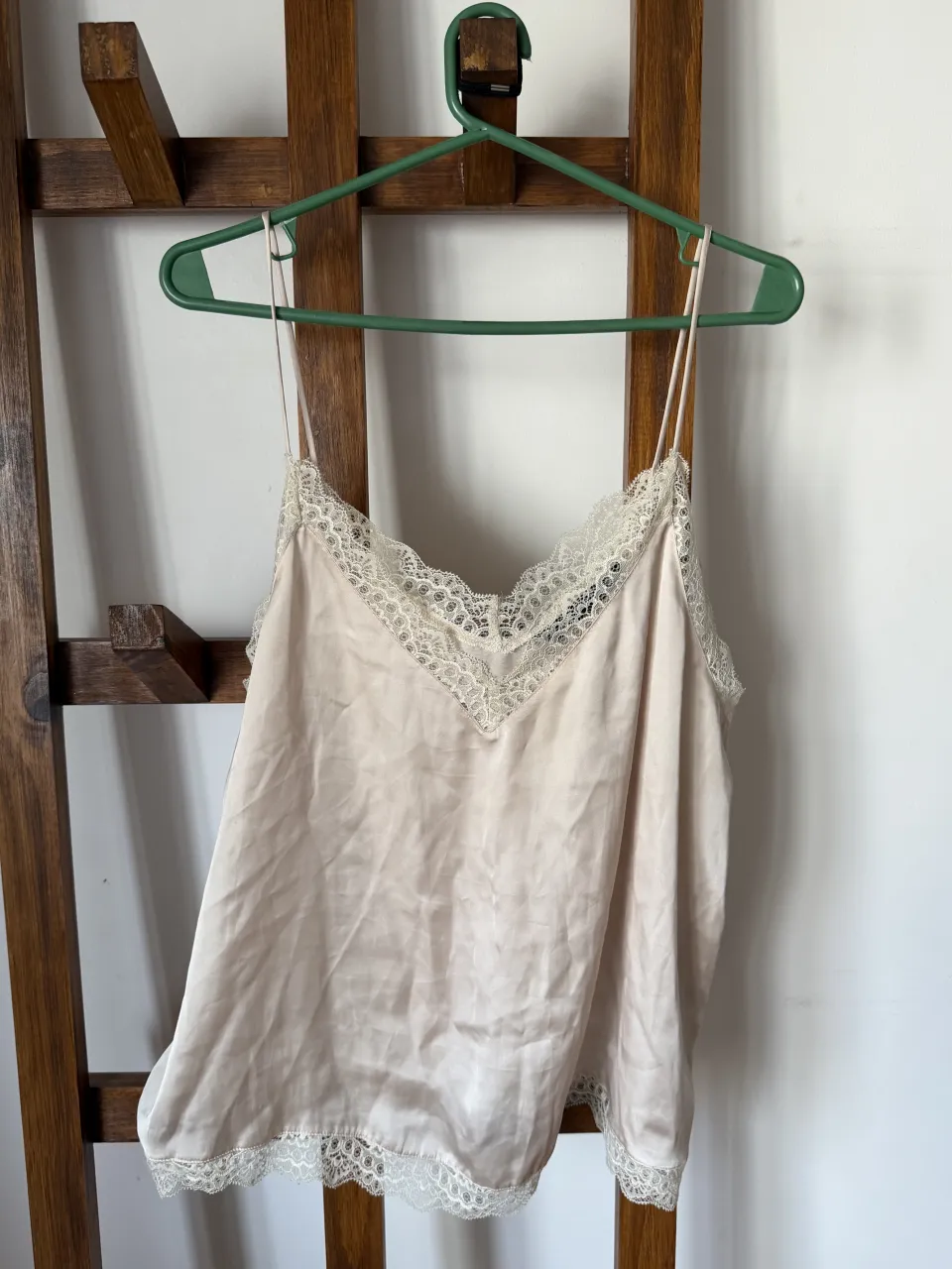 Top de seda color crudo con detalles de encaje en escote y ruedo. Breteles finos regulables. Ideal para usar como prenda interior o como top para un look delicado y romántico.