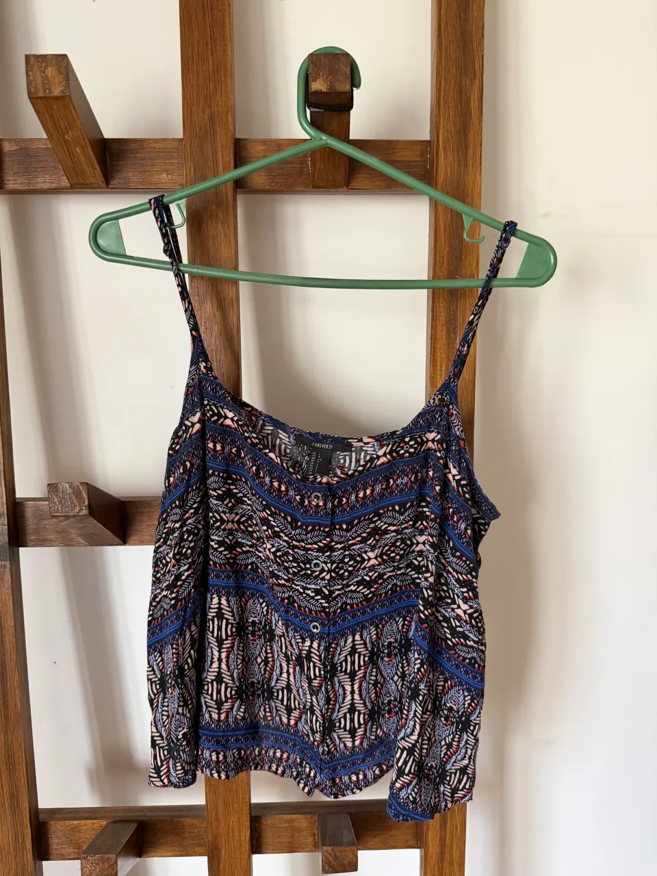 Top estampado con breteles finos y botones al frente. Ideal para un look fresco y canchero.