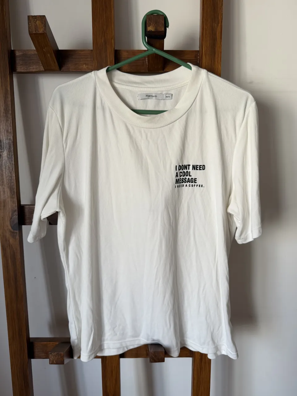 Remera blanca de algodón con estampa "I DON'T NEED A THERAPIST. I JUST NEED A COFFEE." en la parte delantera. Diseño minimalista y moderno, ideal para el día a día.