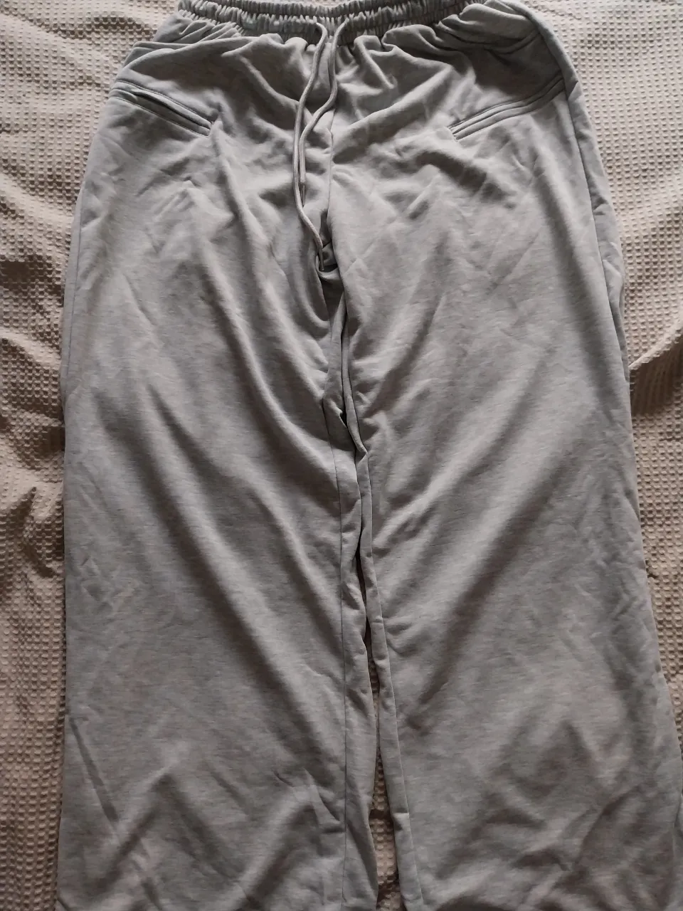 Pantalón de algodón gris con cordón en la cintura y bolsillos.