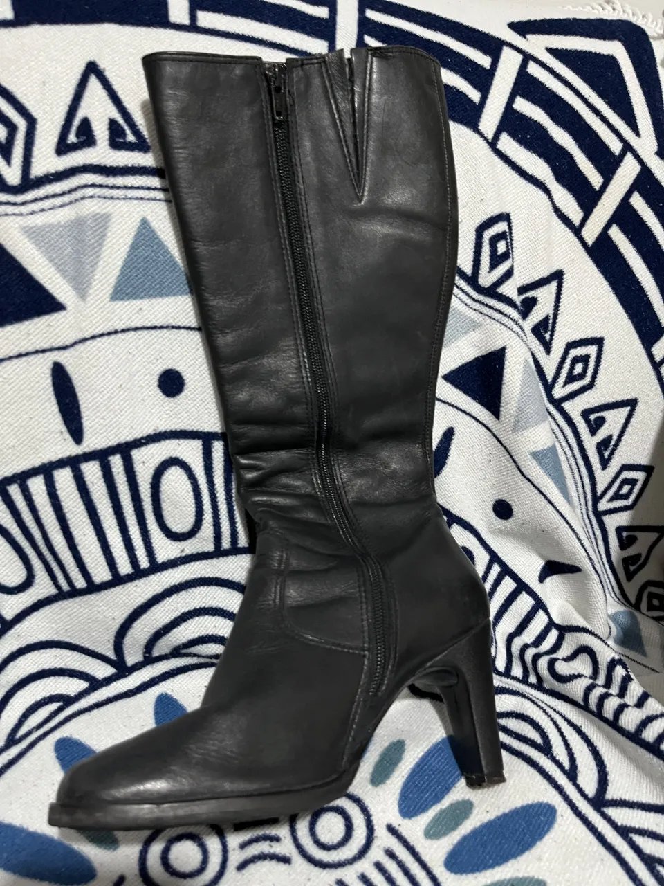 Botas de cuero negras, caña alta, con cierre lateral y taco. Ideales para complementar looks de invierno o para ocasiones especiales.