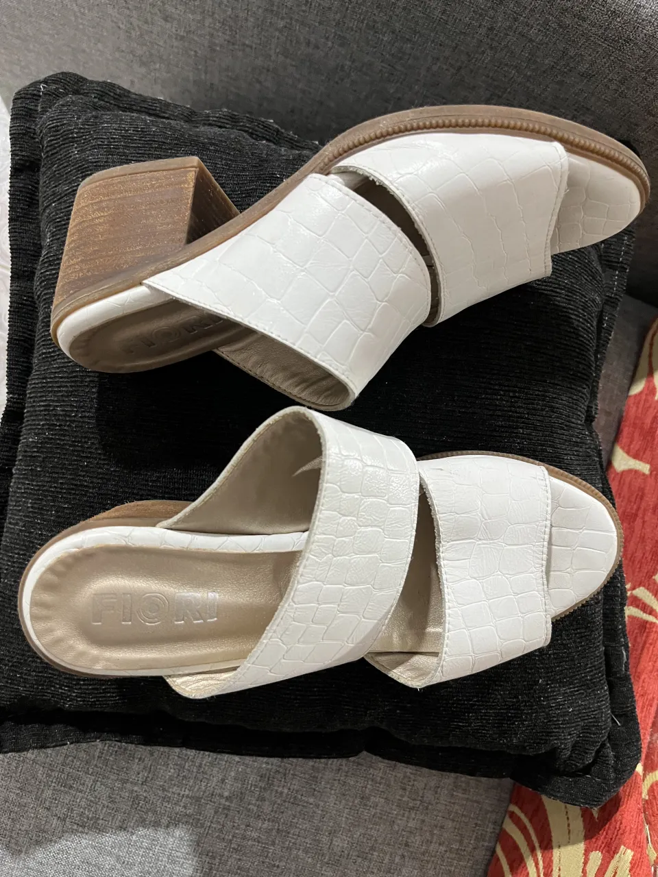 Sandalias blancas con taco de madera y textura de cocodrilo. Ideales para un look canchero y cómodo.
