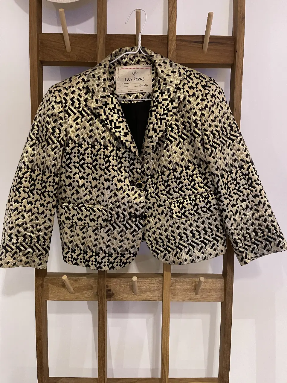 Elegante blazer de mujer con estampado geométrico en tonos dorados y negros. Ideal para un look sofisticado y moderno. Perfecto para eventos formales o para darle un toque chic a tu outfit diario.