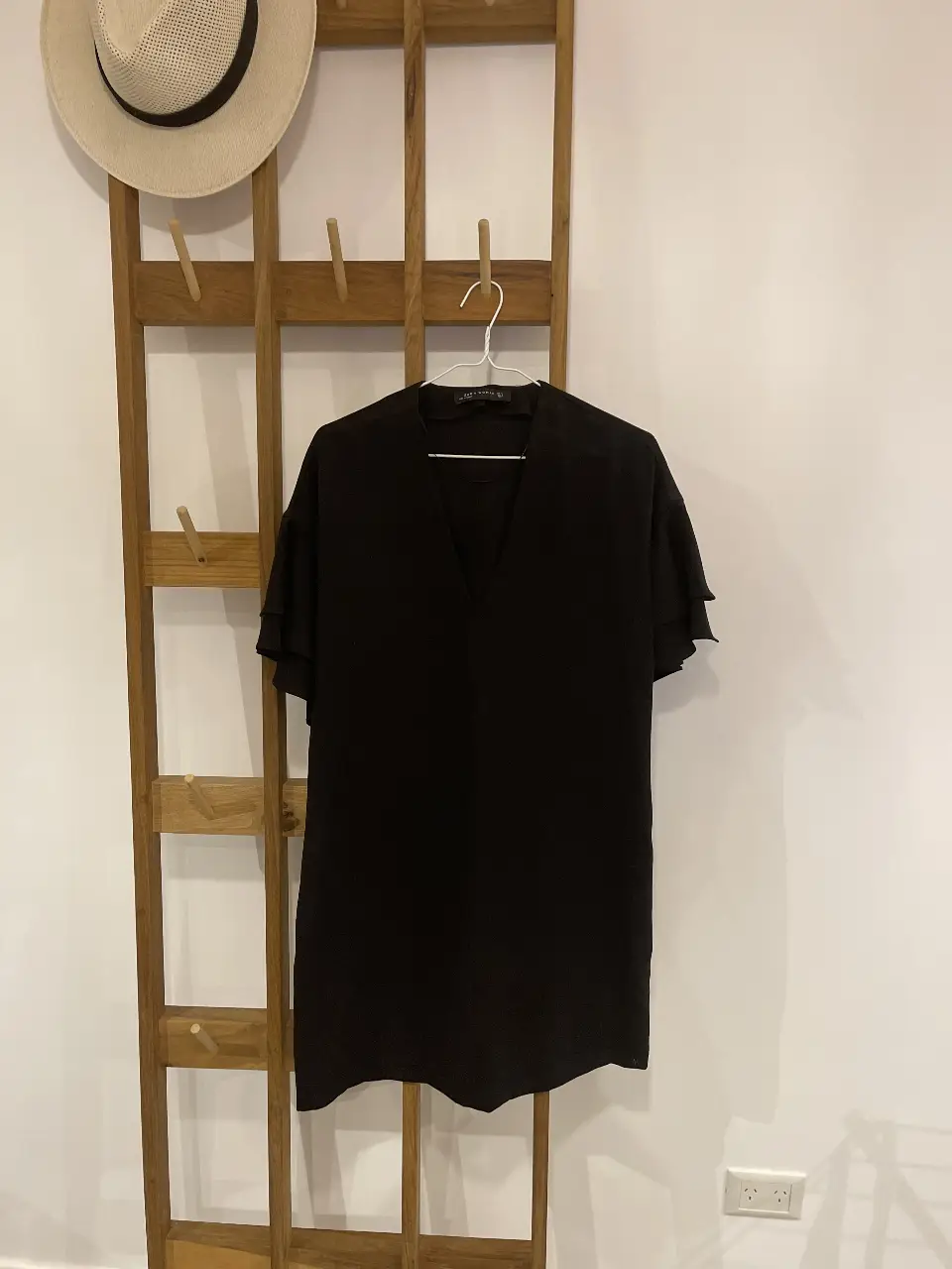Vestido negro de Zara Woman, con cuello en V y mangas con volados. Ideal para una salida o evento.