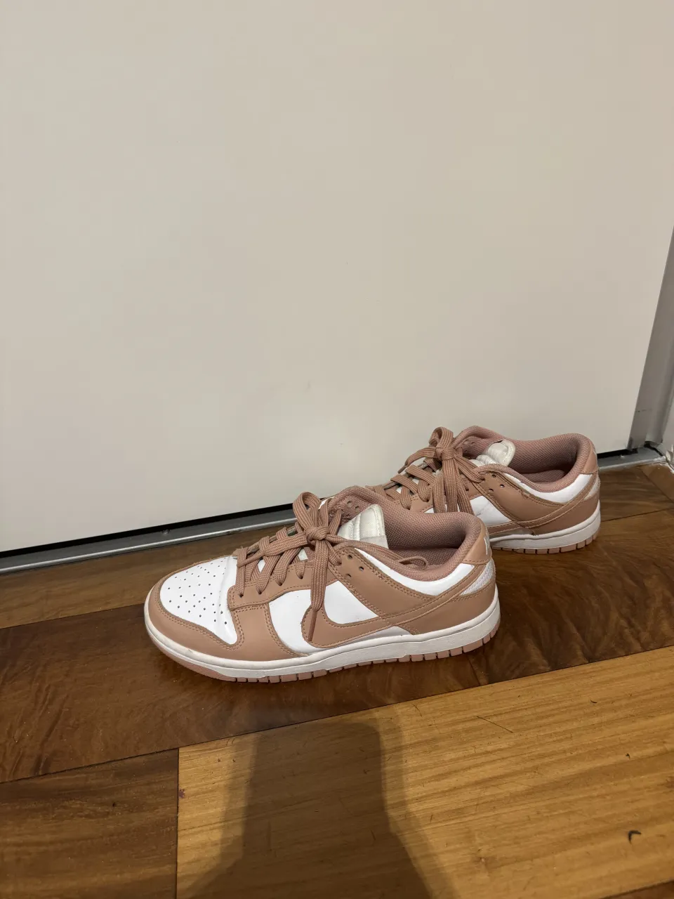Zapatillas deportivas bajas de cuero y gamuza, con cordones y suela de goma. Combinan blanco y rosa pálido.