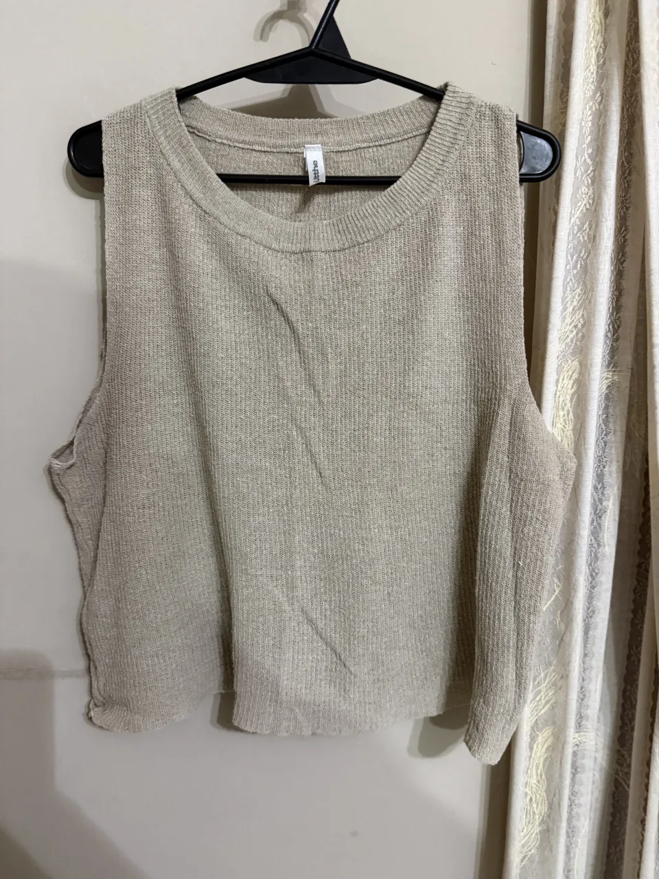 Musculosa de tejido de punto color crudo. Posee cuello redondo.