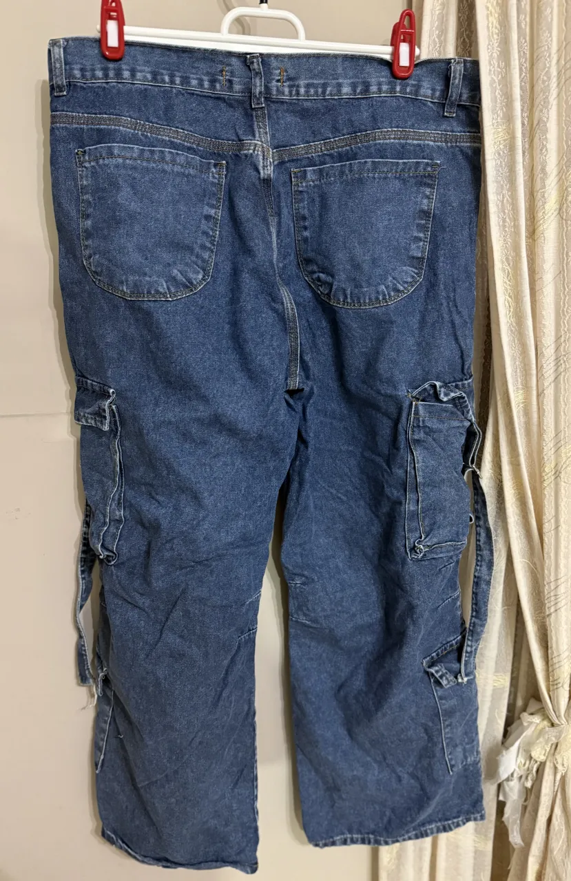 Jean de tiro medio con bolsillos cargo en los laterales. Posee detalles de costuras y un pequeño detalle de rotura en uno de los bajos.