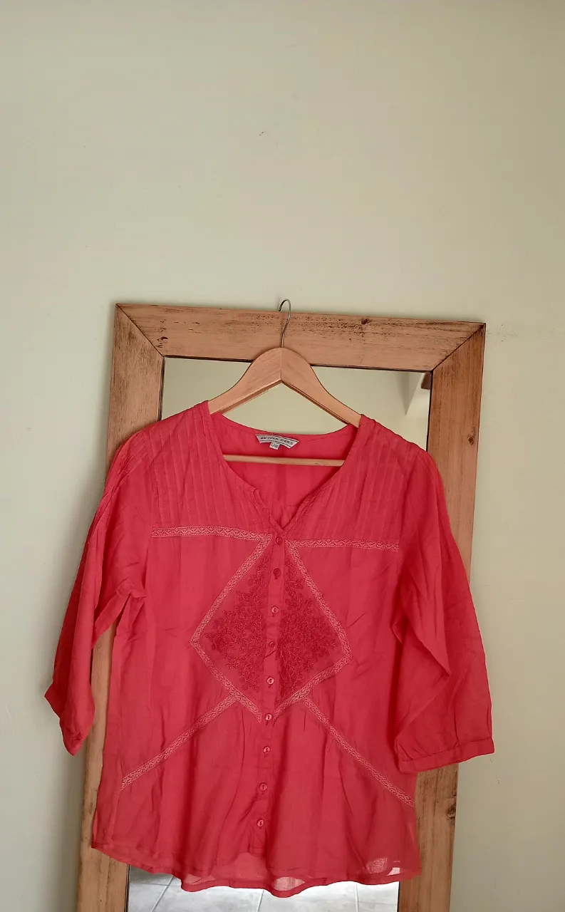 Remera de manga 3/4 de color coral con detalles de bordado y botones en la parte delantera.Medidas 40 de hombro,48 de sisa, 68 de largo