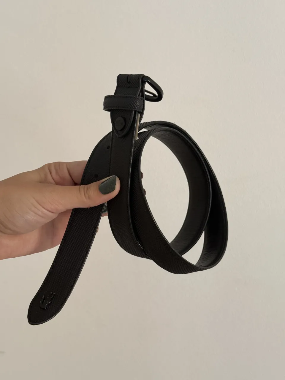 Cinturón de cuero negro con hebilla metálica. Presenta el logo de la marca en la punta y en la parte interna de la hebilla. Mide aprox 92cm. 