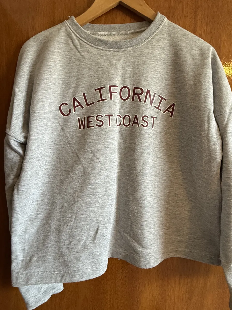 Buzo gris con estampa "CALIFORNIA WEST COAST" en color bordó.