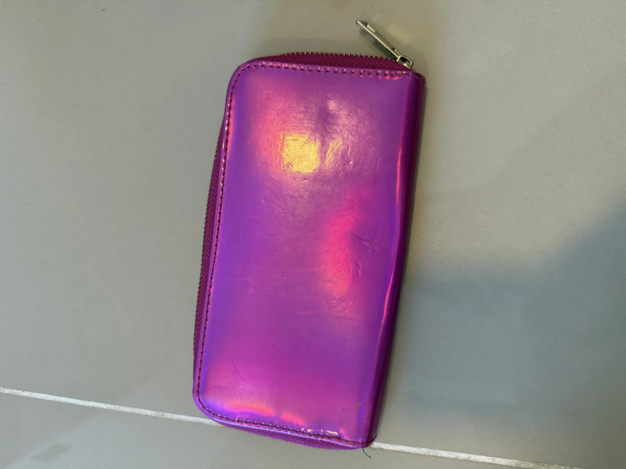 Billetera fucsia metalizada con cierre.