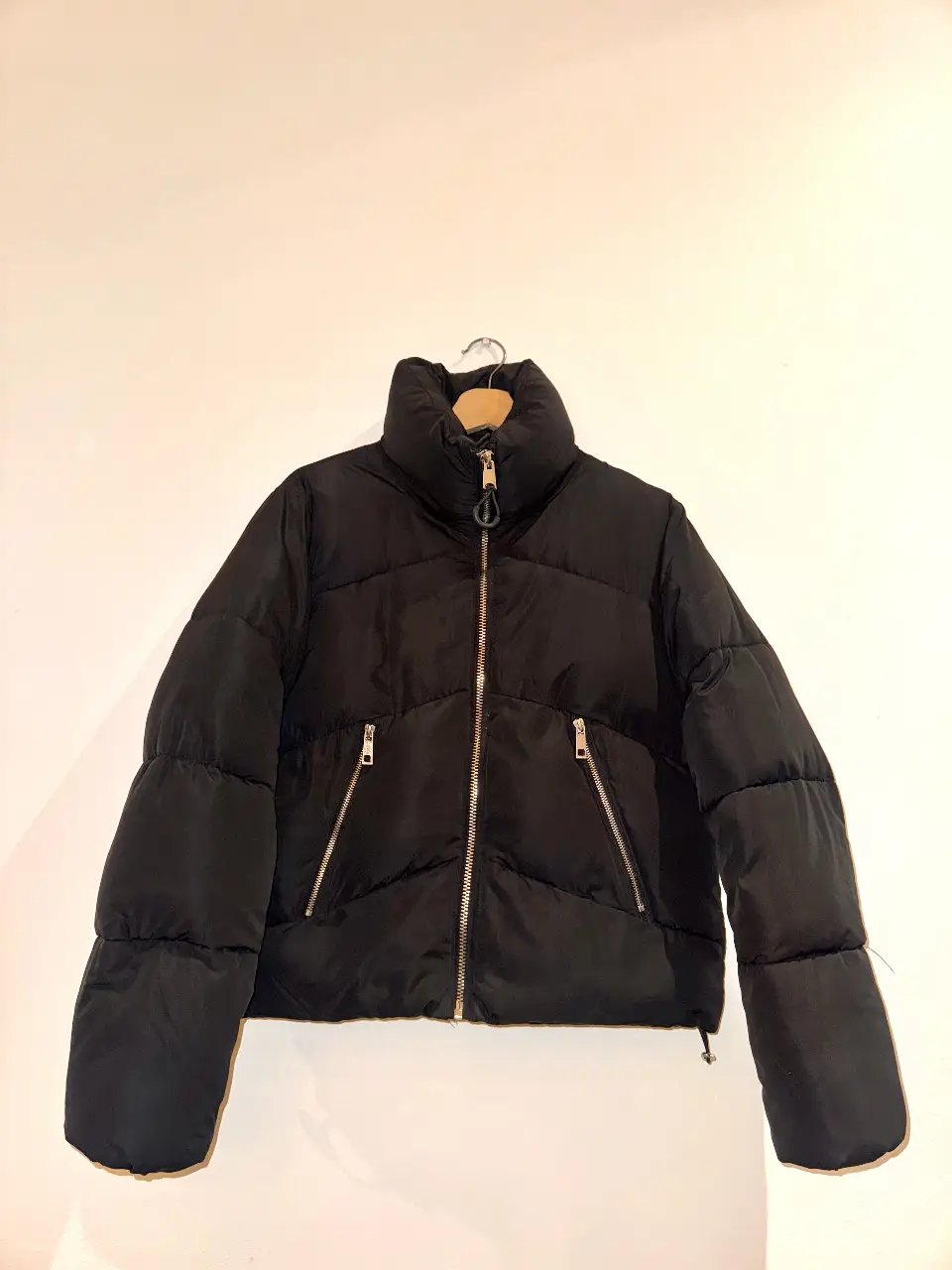 Campera puffer negra. Con cierre frontal y bolsillos con cierre. Cuello alto para mayor abrigo.