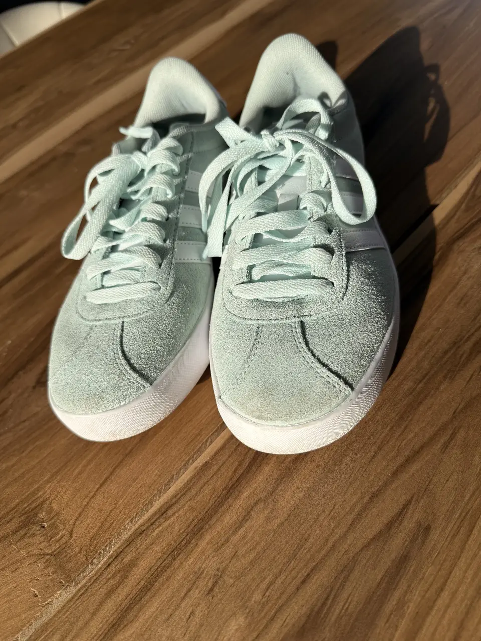Zapatillas Adidas Gazelle celestes con detalles blancos. Diseño clásico de gamuza con suela de goma. Ideales para un look casual y cómodo.