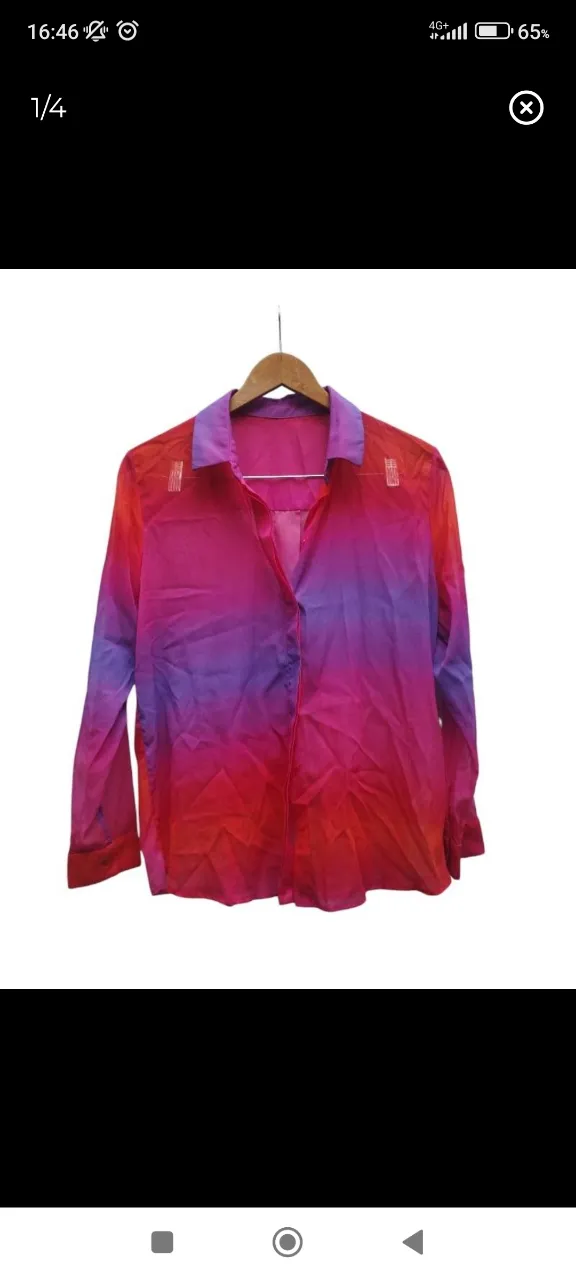Camisa de manga larga con cuello. Posee un degradado de colores vibrantes que van del rojo al rosa y al violeta.